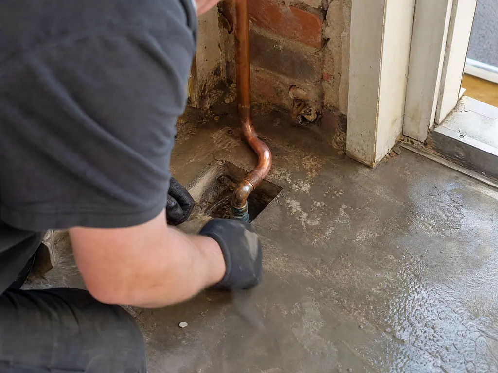 Copper pipe exposed under a concrete floor at the leak, Nottingham