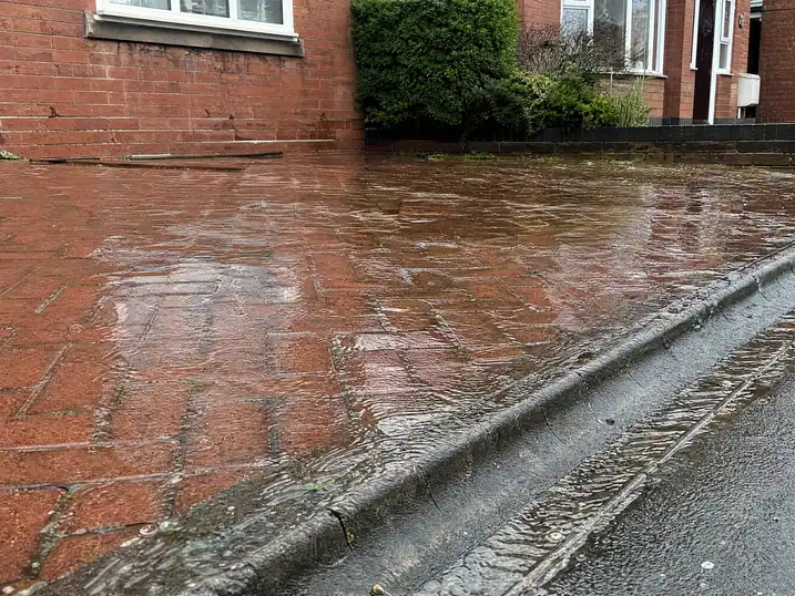 Water pooling on block paving from a burst supply pipe, Nottingham