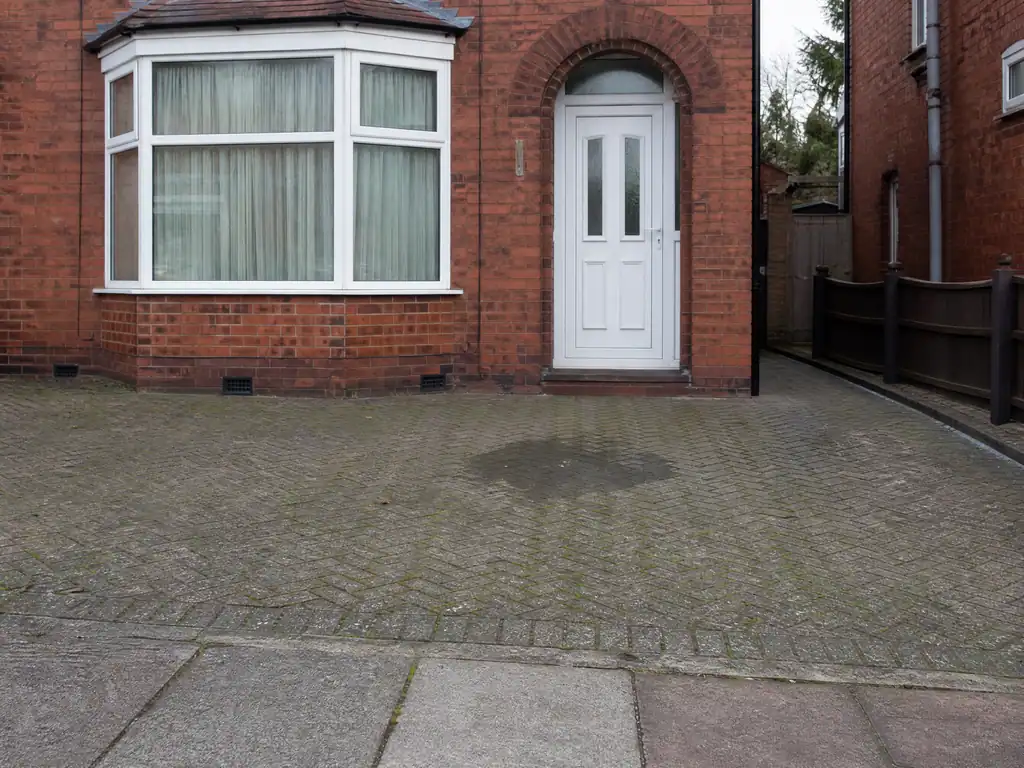 Wet patch on a block-paved drive over a hidden supply pipe leak, Nottingham